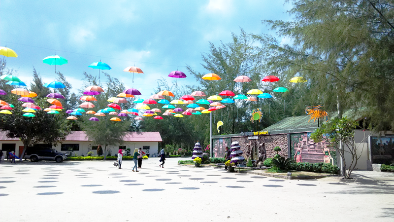 Payung warna warni yang bergantungan di halaman restoran Pantai Bali Lestari